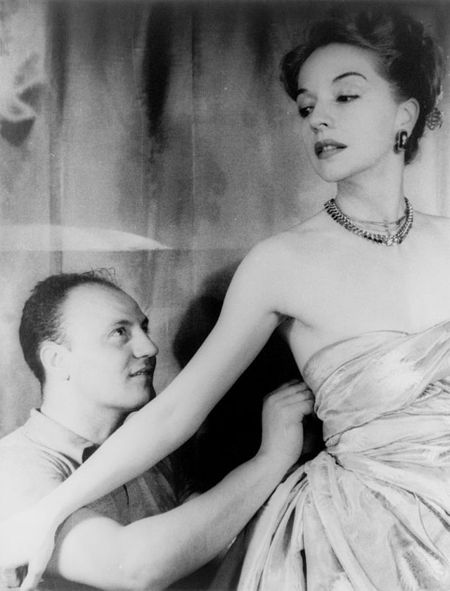 Nhà thiết kế Pierre Balmain và Ruth Ford trong trang phục của ông. Ảnh chụp năm 1947. Nguồn: wiki